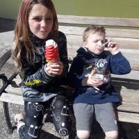 Little girl and boy eating ice cream cones and in a dish